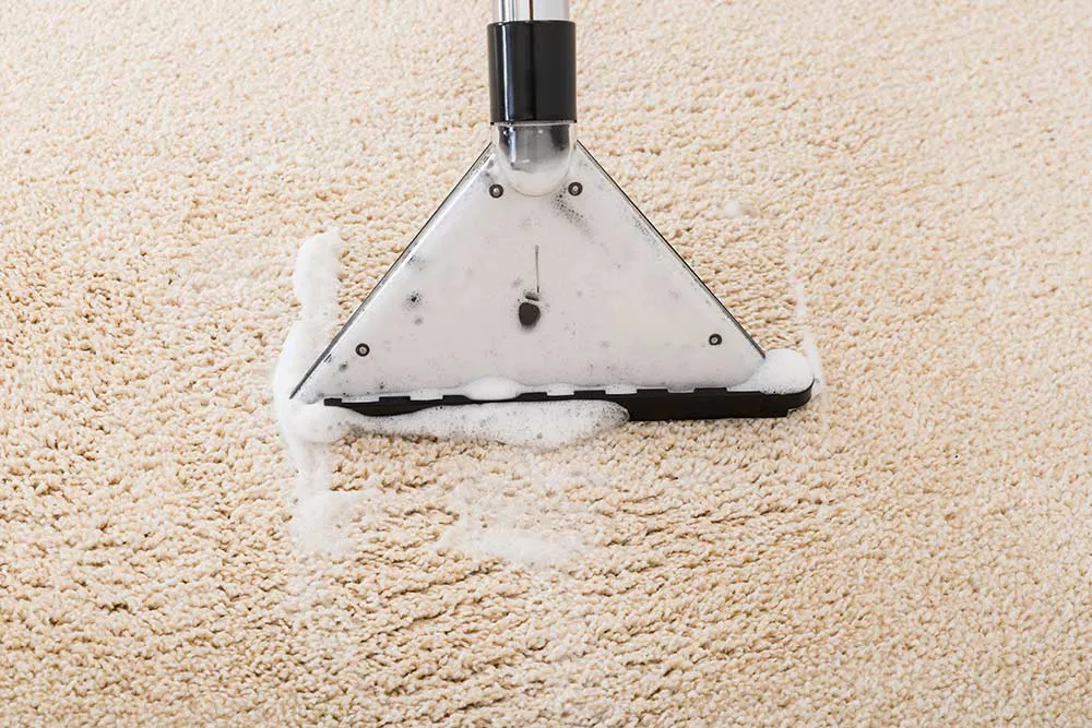 Carpet shampooer being used to remove suds from carpet.