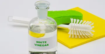 Bottle of vinegar with cleaning tools